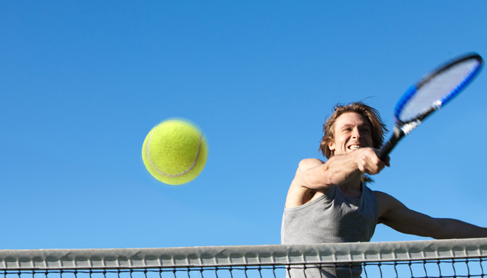 tennis player hitting ball