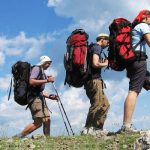 three backpackers hiking mountain