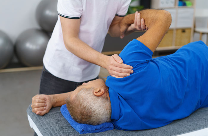 therapist working with patients healing shoulder