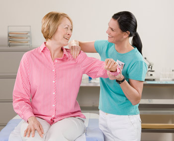 therapist helping lady with hurting shoulder