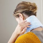 woman with neck pain and cooling pad
