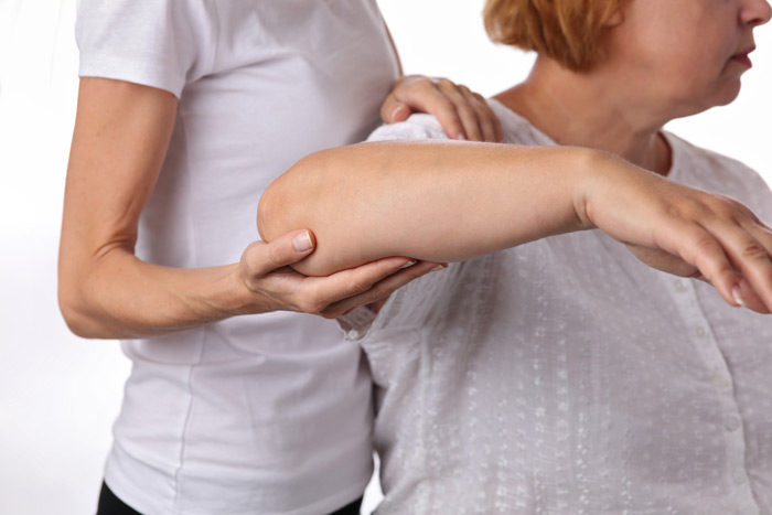 physical therapist helping woman after shoulder surgery